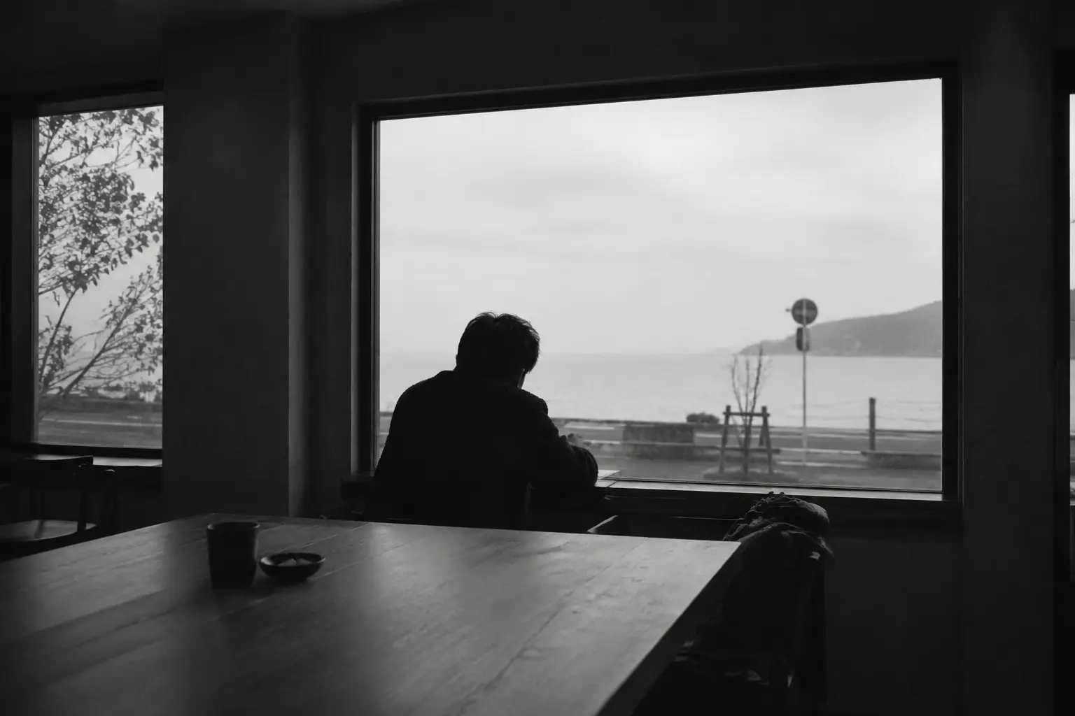 A quiet figure beside a cafe window